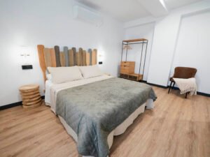 Habitación de diseño en la casa rural Casa Cancela en Palas de Rei, con cama de matrimonio, mobiliario de estilo industrial y suelo de madera, perfecta para peregrinos