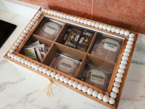 Caja de madera decorativa con una variada selección de tés e infusiones de cortesía para los huéspedes del apartamento de Casa Cancela en Palas de Rei.