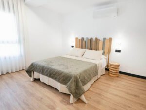 Habitación doble acogedora en Casa Cancela con cabecero original hecho de remos de madera, aire acondicionado y decoración de estilo marinero y rural.