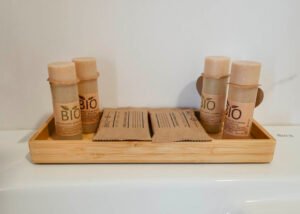 Set de jabones y productos de higiene bio en Casa Cancela, en Palas de Rei, presentados en bandeja de madera con envases sostenibles de extractos de plantas para el cuidado de los huéspedes.
